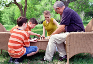 older person playing chess with kids