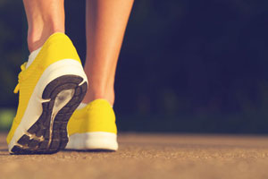 Someone walking, wearing yellow shoes.