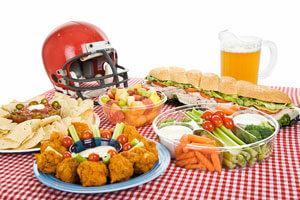 Table set with different foods, pitcher and football helmet.