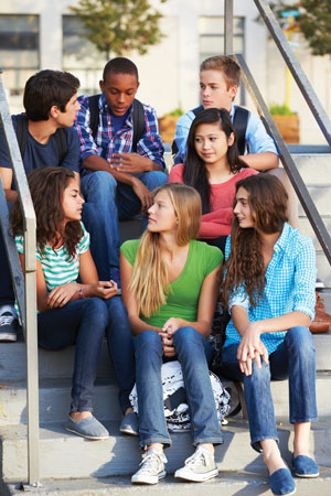 Group of teenagers sitting on steps outside.