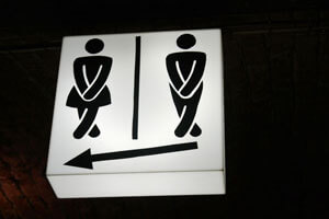 Male and female bathroom signs with their legs crossed.