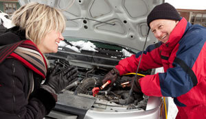 Man and woman working on a car engine.