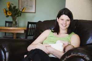 Female with dark hair breastfeeding a baby.