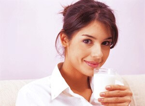 Young woman drinking a glass of milk.
