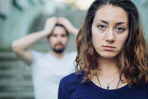 Girl looking at camera/ away from frustrated man