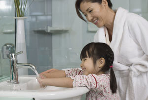 mom watching daughter wash hands