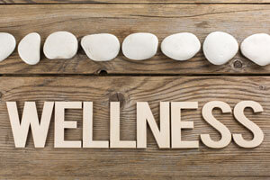 The word "wellness" spelled out on wood planks