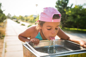 girl drinking out of water fountain