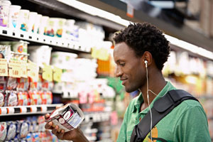 Young male looking at a food product in a store.