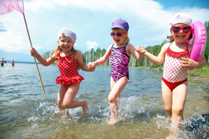 Three young girls playing in a lake