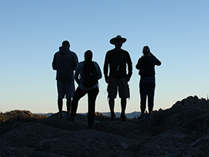 Group of four people standing on a mountain