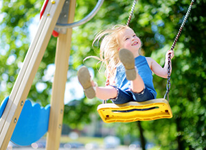 child on playground swing