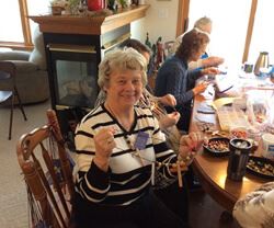 Kay Sime and faith community friends making prayer bead necklaces using Pass it on Crosses.